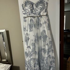 A white and sliver blue dress that is Strapless with corset like back.